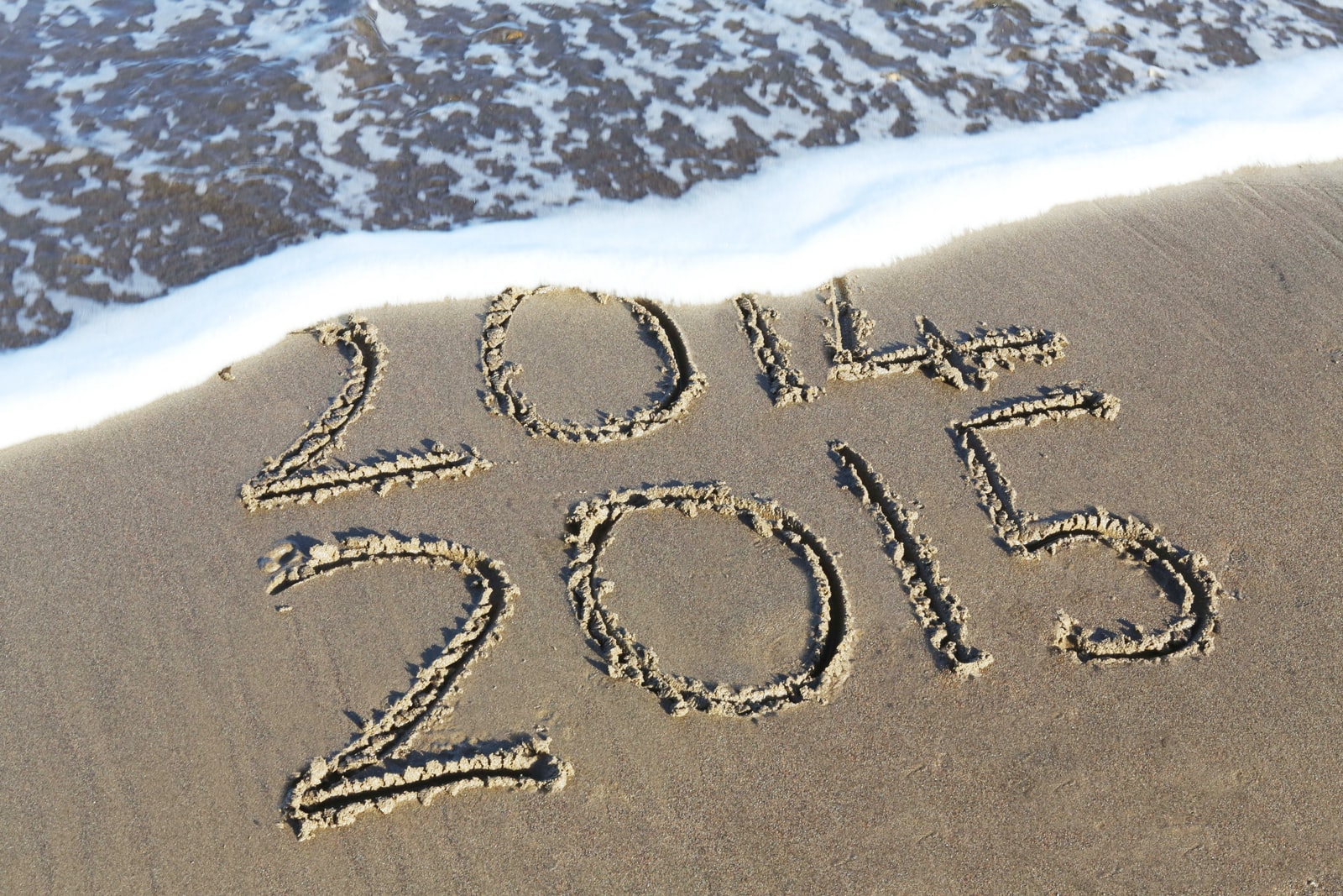 beach shore etch with 2014 and 2015 texts during daytime